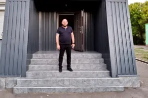 Міський голова Сергій Каліман стоїть біля входу до релокованої міської ради Василівки в Запоріжжі, 1 вересня 2024 року