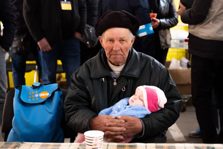 Дідусь Валентин з онукою в центрі для переселенців у Запоріжжі. Квітень 2022 року. Фото: Павло Пашко.