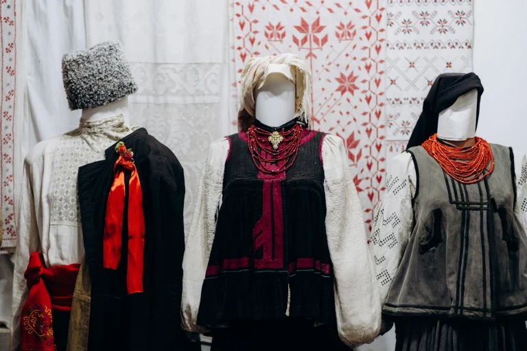 традиційні українські народні костюми, що складаються з вишитих сорочок, керсеток (жилетів) та коралових намист, представлених на манекенах. Фото: Софія Соляр.