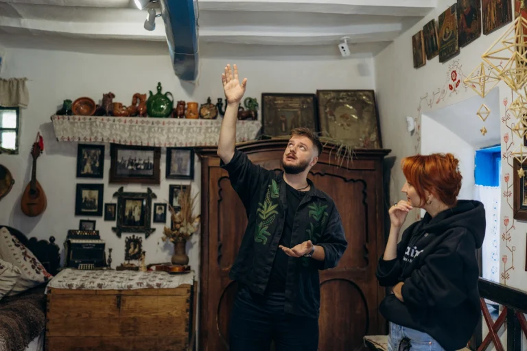 Володимир Попов показує продюсерці експедиції головну балку під стелею хати - сволок. Фото: Софія Соляр.